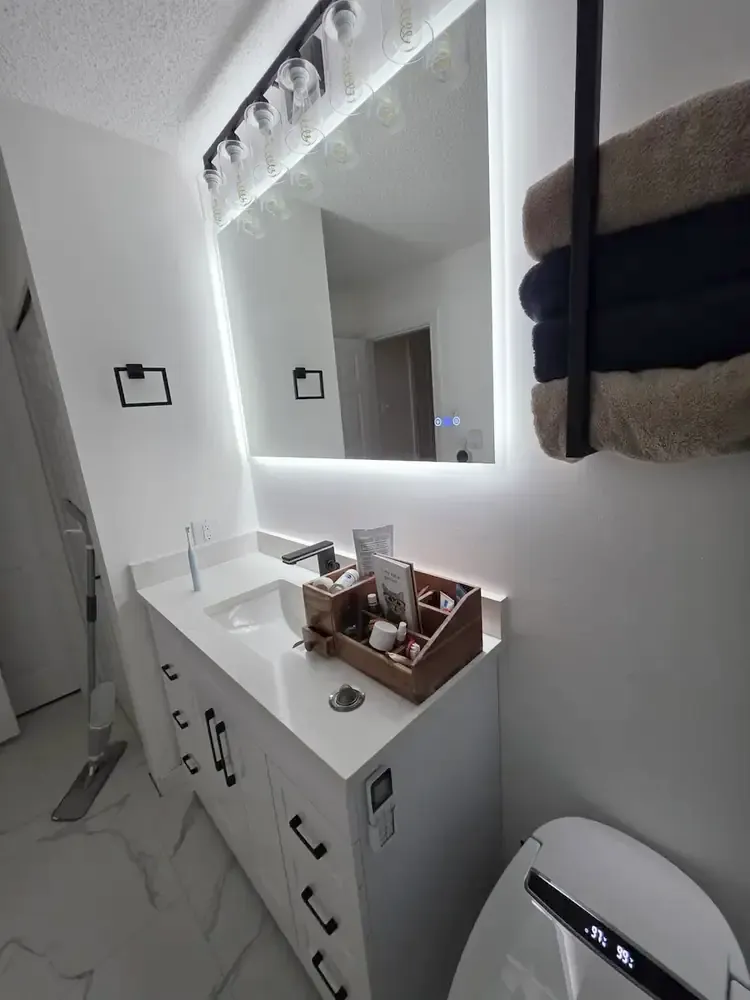 Custom vanity area with backlit mirror and lighting installation
