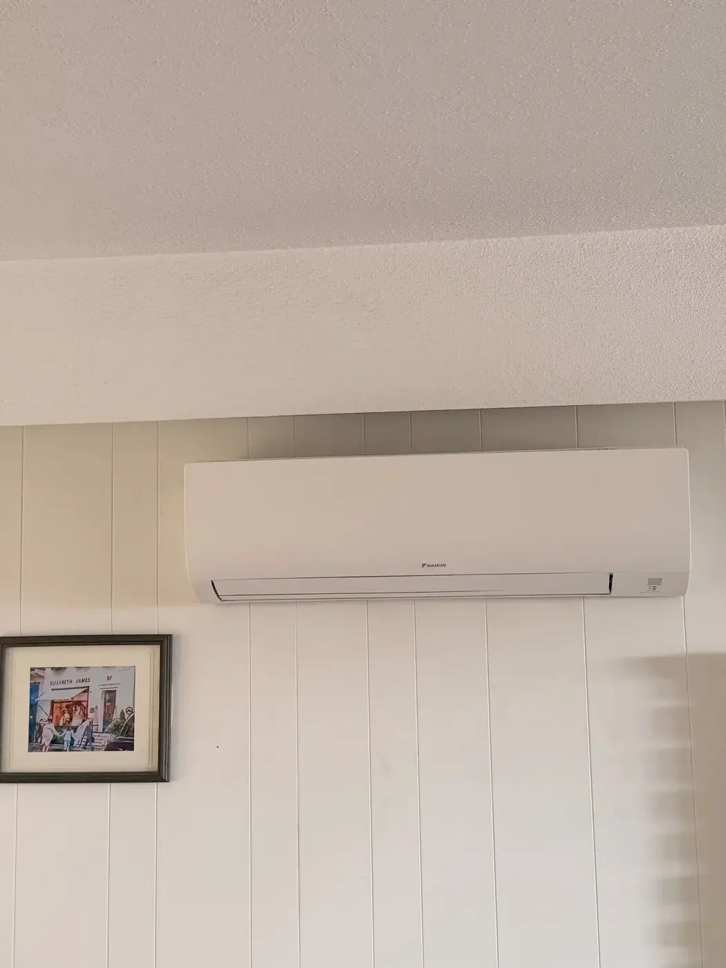 Wall-mounted ductless heat pump head installed in a living room