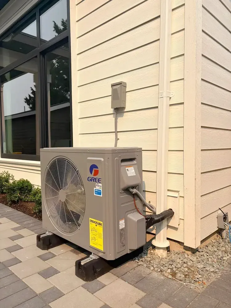 Outdoor Gree heat pump unit installed beside a home