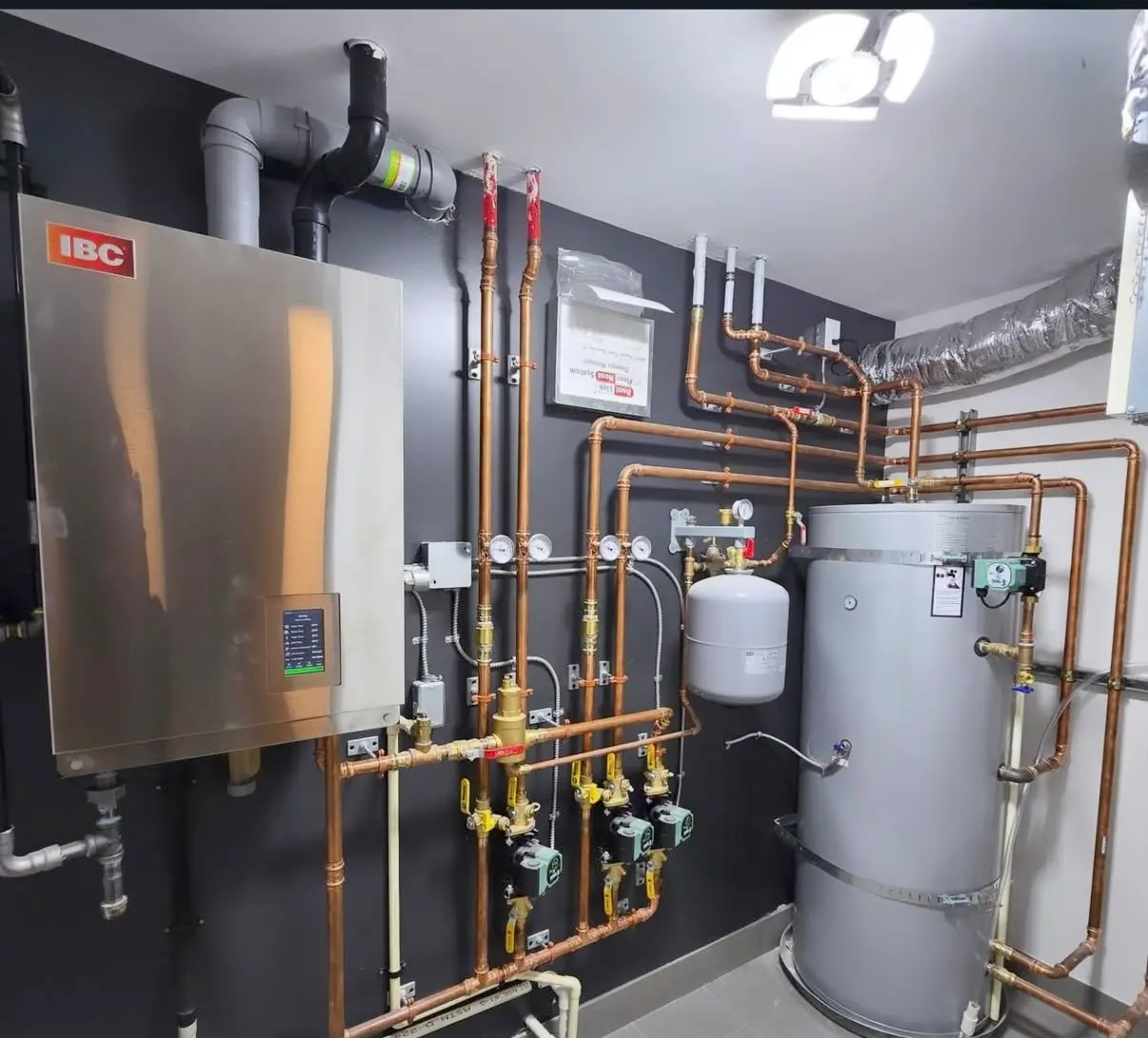 High-efficiency boiler and indirect hot water tank with copper piping, pumps and gauges