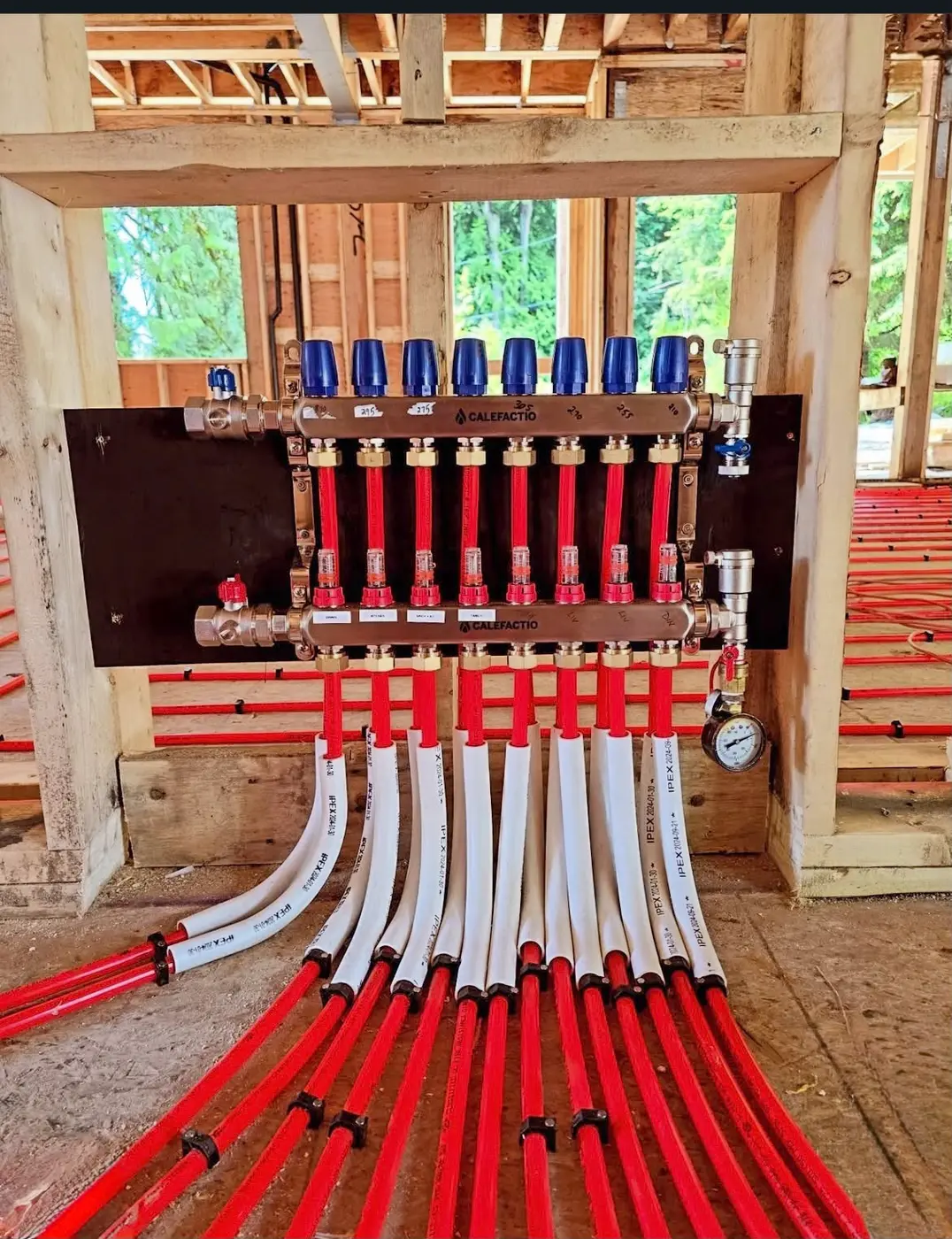 Radiant floor heating manifold with labelled zones and PEX lines