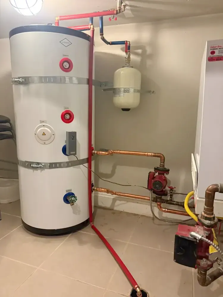 Water heater tank with copper piping and circulation pump in a mechanical room